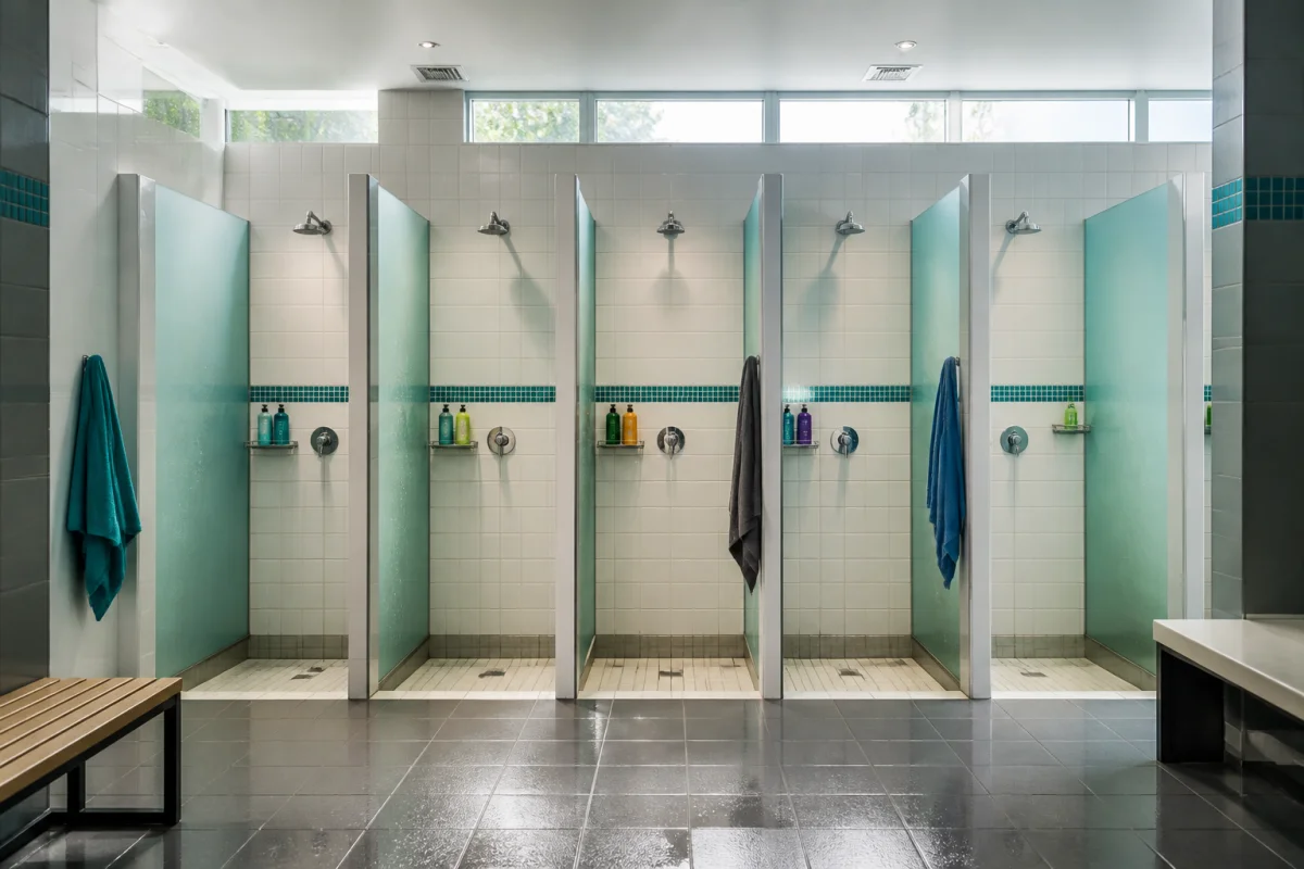 Cabines de douche individuelles dans le vestiaire moderne d’une salle de sport Basic-Fit