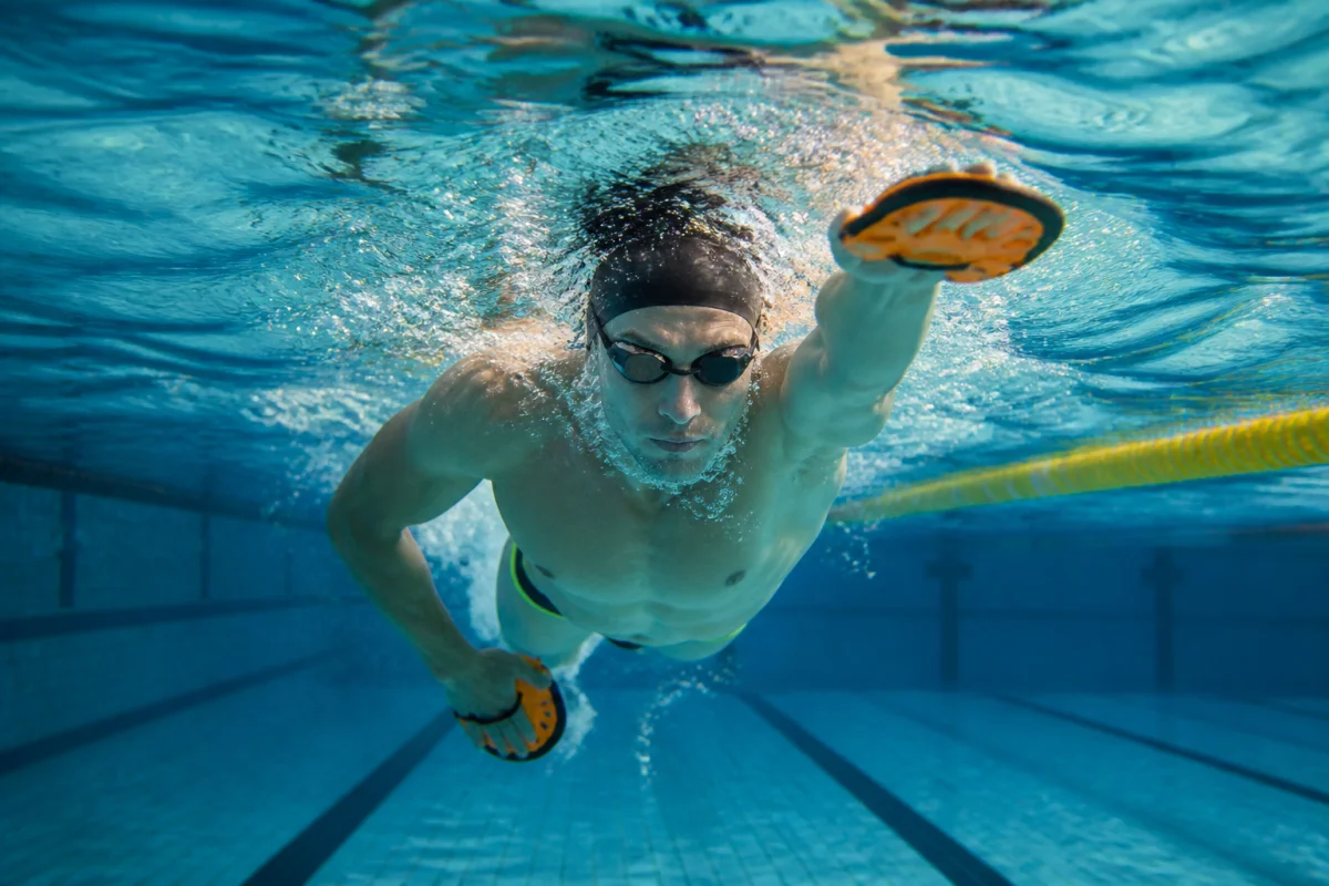 Nageur adulte perfectionnant sa prise d’appui en crawl pour améliorer sa nage en piscine.